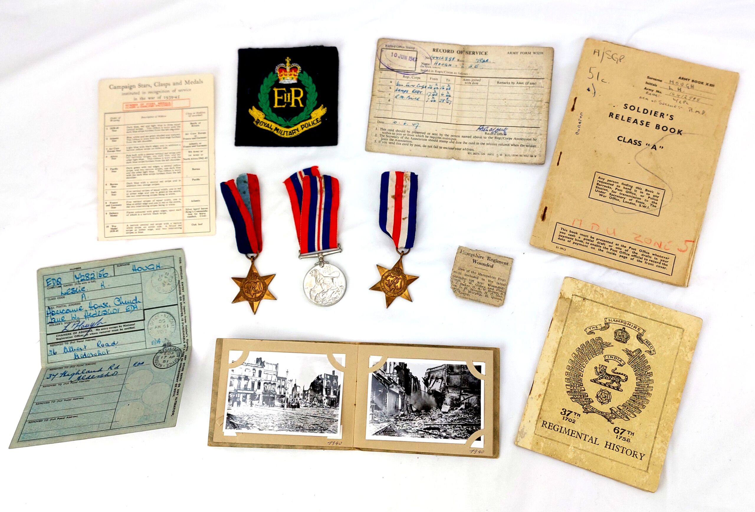 British, WW2, Medals and Service records for L.Cpl Leslie H.E. Hough, The France and Germany Star, The 1939-1945 Star, The WW2 War Medal 1939-1945, WW2 Issue letter for medals, Record of Service, The Hampshire Regt (36th & 7th Foot) Regimental History Booklet, Newspaper Clipping of Hampshire Reg't Wounded, EIIR Royal Military Police Blazer Badge, Soldier's Release Book Class A, National Registration Identity Card, Book of 12 B&W Photographs 1940-1944 Oostende